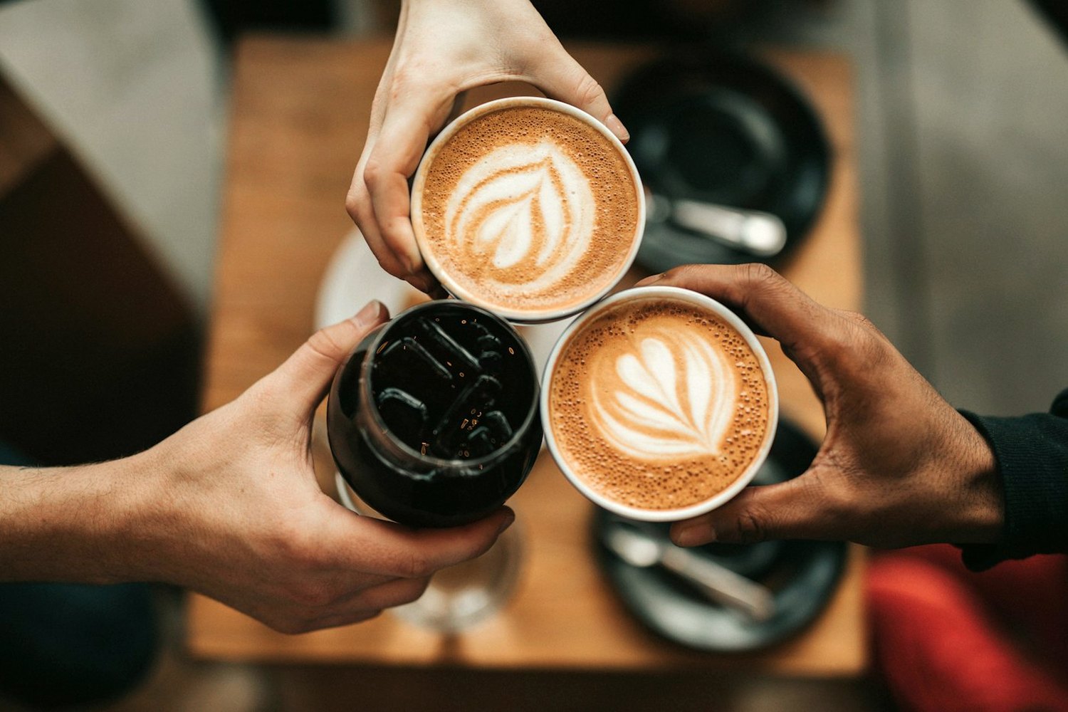 Personas brindando con tazas de café