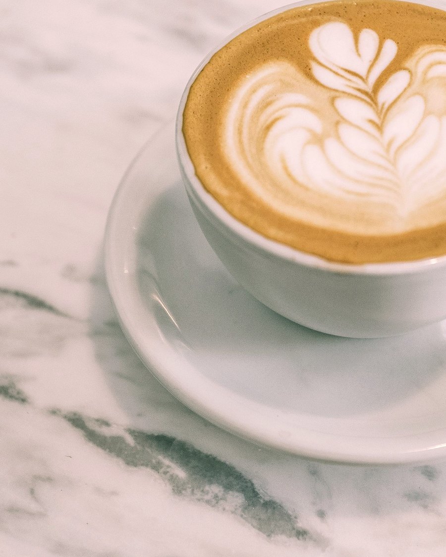 Taza de café con arte latte sobre mármol